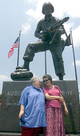 Billie Murphy, left, and Nadene Lokey, right, stand in front of a statue of their brother, World War II hero and movie star Audie Murphy, after an unveiling of the statue Saturday, June 22, 2002 in Greenville, Texas. Greenville sculptor Gordon Thomas created the image of Murphy in combat, perched on top of a 5-foot-high granite base. The sculpture along Interstate 30 is near the Audie Murphy/American Cotton Museum in Greenville, one of several area towns to claim Murphy as a hometown hero. Photo by Dawn Dietrich