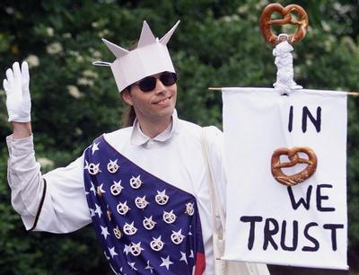 Ein als Freiheitsstatue verkleideter Demonstrant trgt in Berlin am Dienstag bei einer Demonstration gegen den bevorstehenden Besuch von US-Prsident George W. Bush ein Plakat mit der Aufschrift ''In 'Brezel' we trust''. Prsident Bush hatte sich an einer Brezel verschluckt und ist darauf hin bewusstlos geworden.