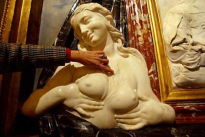 A statue of a bare-breasted woman, one of a pair of busts designed by Bernini, comes under close scrutiny at the Sant'Isidoro Church in central Rome on October 22, 2002. Restoration works in a Roman church have revealed two bare-breasted beauties designed by Bernini but hidden behind bronze 'corsets' for more than 100 years, officials said. Photo by Giampiero Sposito