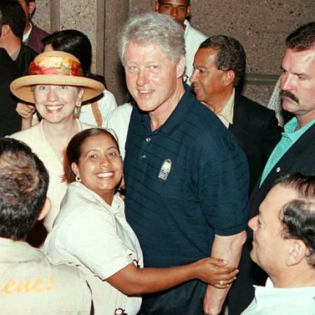 The last legally elected President, Bill Clinton, center, accompanied by his wife, Sen. Hillary Rodham Clinton, left, is embraced by an unidentified Dominican woman during his visit to Higuey, Dominican Republic, on Monday, April 1, 2002. Photo by Wilfredo Rubert & Listin Diario)