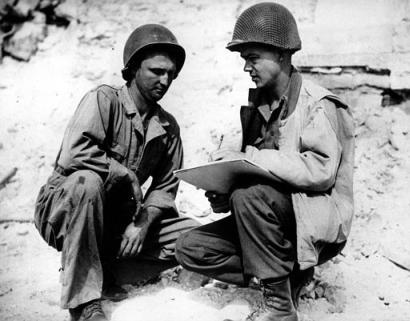 Pvt. Robert L. Bowman, left, of Hogansville, Ga., poses for Stars and Stripes artist Sgt. Bill Mauldin, on the Anzio beachhead in Italy during World War II in May, 1944. The completed picture will be known as 'G.I. Joe.'