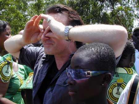 Irish rock star Bono lends his blue Bulgari wrap-around shades to Felicia Boateng, 12, a schoolgirl who asked him to sing for her classmates in Richard Akwei Memorial School in Ghana's capital Accra, May 22, 2002. Bono told her she was 'genuinely cool'. Bono, on a tour of Africa with U.S. Treasury Secretary Paul O'Neill, sang U2 hit 'Still haven't found what I'm looking for'. Photo by David Clarke