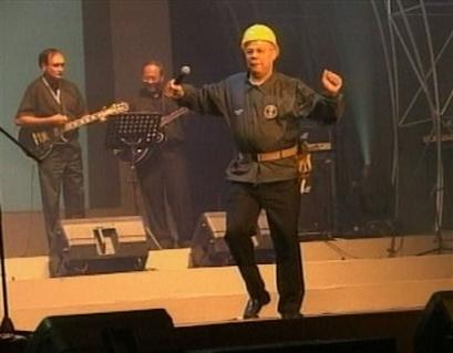 Colin Powell, US Secretary of State, performs a version of the Village People's hit disco song 'YMCA' at the conclusion of Asia's largest security meeting in Jakarta, Indonesia, on Friday July 2, 2004. Powell took to the stage, dressed as a construction worker Friday, with other unidentified US diplomats to deliver their rendition of the 1970's hit song to an audience of Asia Security meeting delegates.