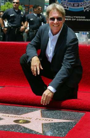 Actor Harrison Ford poses with his newly unveiled star on the Hollywood Walk of Fame May 30, 2003 in Hollywood. Ford's new film 'Hollywood Homicide' was filmed along Hollywood boulevard and opens June 2003. Photo by Fred Prouser