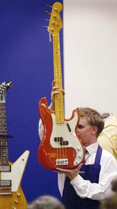 A Sotheby's employee holds up the Fender Precision bass guitar known as 'Frankenstein' that was owned by the Who's bass guitarist John Entwistle and sold at auction for 62,400 pounds including buyers premium (US$95,000) in London Tuesday May 13, 2003. It was bought by a private collector in Los Angeles who declined to be named. The guitar is called 'Frankenstien ' as it is built from the remains of five guitars smashed prior to 1967. Photo by Alastair Grant