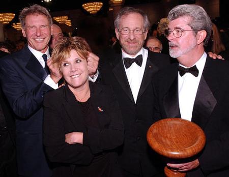 George Lucas, right, jokes with, from left, Harrison Ford, Carrie Fisher, and Steven Spielberg, after being presented with the Stanley Kubrick Britannia Award for Excellence in Film at the BAFTA/LA 11th Annual Britannia Awards, in Beverly Hills, Calif., Friday, April 12, 2002. Photo by Lucy Nicholson