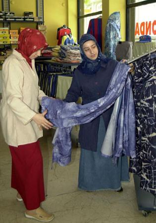 Two Turkish women look at Islamic bathing suits in a shop in Istanbul, Turkey, in this Aug. 9, 2002 photo. Islamic bathing suits fit loosely so as not to show off the outlines of women's body and are made of a synthetic material that dries quickly. The overwhelming majority of women at beaches in secular Turkey wear western-style bathing suits. Photo by Osman Orsal