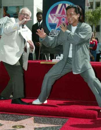 Action film star Jackie Chan (R) strikes a pose with honorary mayor of Hollywood Johnny Grant after Chan was honored with a star on the Hollywood Walk of Fame, October 4, 2002 in Hollywood. Chan stars in the new comedy film ''The Tuxedo.'' Photo by Fred Prouser