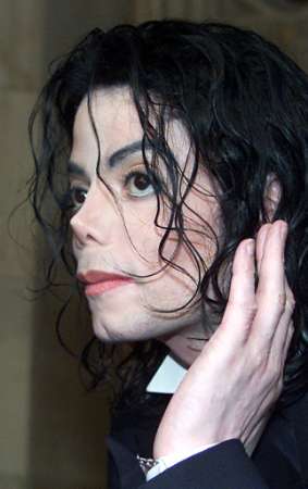 U.S. pop singer Michael Jackson gestures as he answers questions from the media on arrival at the House of Lords at the Palace of Westminster in central London, June 14, 2002. Photo by Michael Crabtree