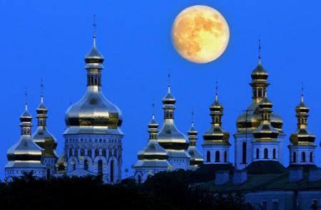 Full moon rises in the night sky above golden domes of the Orthodox Monastery of Caves in Kiev, Ukraine, on Sunday, June 23, 2002. Photo by Efrem Lukatsky