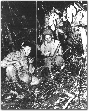 Corporal Henry Bahe, Jr. (left) & Private First Class George H. Kirk, Navajos with a Marine Signal Unit, operate a portable radio.