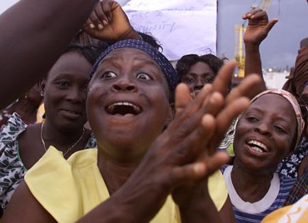 Nigerian women occupying a multimillion dollar ChevronTexaco oil export terminal at Escravos, Nigeria, sing and dance at the main dockyard Monday July 15, 2002. Women occupying a ChevronTexaco oil terminal agreed Monday to end their eight-day siege after the company offered to hire at least 25 villagers and to build schools, electrical and water systems. Photo by Saurabh Das