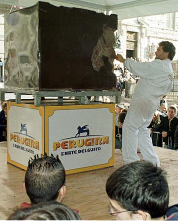 An unidentified artist sculpts a square meter (1.2 square yards) block of chocolate during the chocolate festival Eurochocolate 2002 in Perugia, central Italy, Sunday, Oct. 20, 2002. The festival runs until Oct. 27. Photo by Leonetto Medici