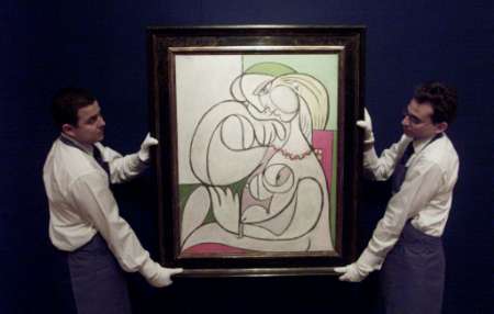 Christie's porters hang the Pablo Picasso painting ''Nu au collier'' at their auction rooms in London May 23, 2002. The painting, which is oil on canvas, is expected to fetch over 6 million pounds (US$8.4million) when it is auctioned in June. Photo by Russell Boyce