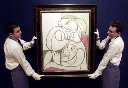 Christie's porters carry the Pablo Picasso painting 'Nu au collier' at their auction rooms in London in this file photo dated May 23, 2002. Photo by Russell Boyce