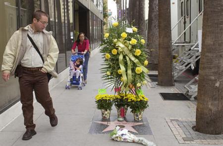 Passers-by look at flowers left on actor Robert Urich's star on the Hollywood Walk of Fame in Los Angeles, Tuesday, April 16, 2002. Photo by Nick Ut