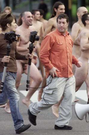 American photographer Spencer Tunick (C) runs with an assistant and some 450 nude models while changing their location in the middle of a photo session along 
Buenos Aires' Avenida 9 de Julio, at daybreak on April 6, 2002. Photo by Rickey Rogers